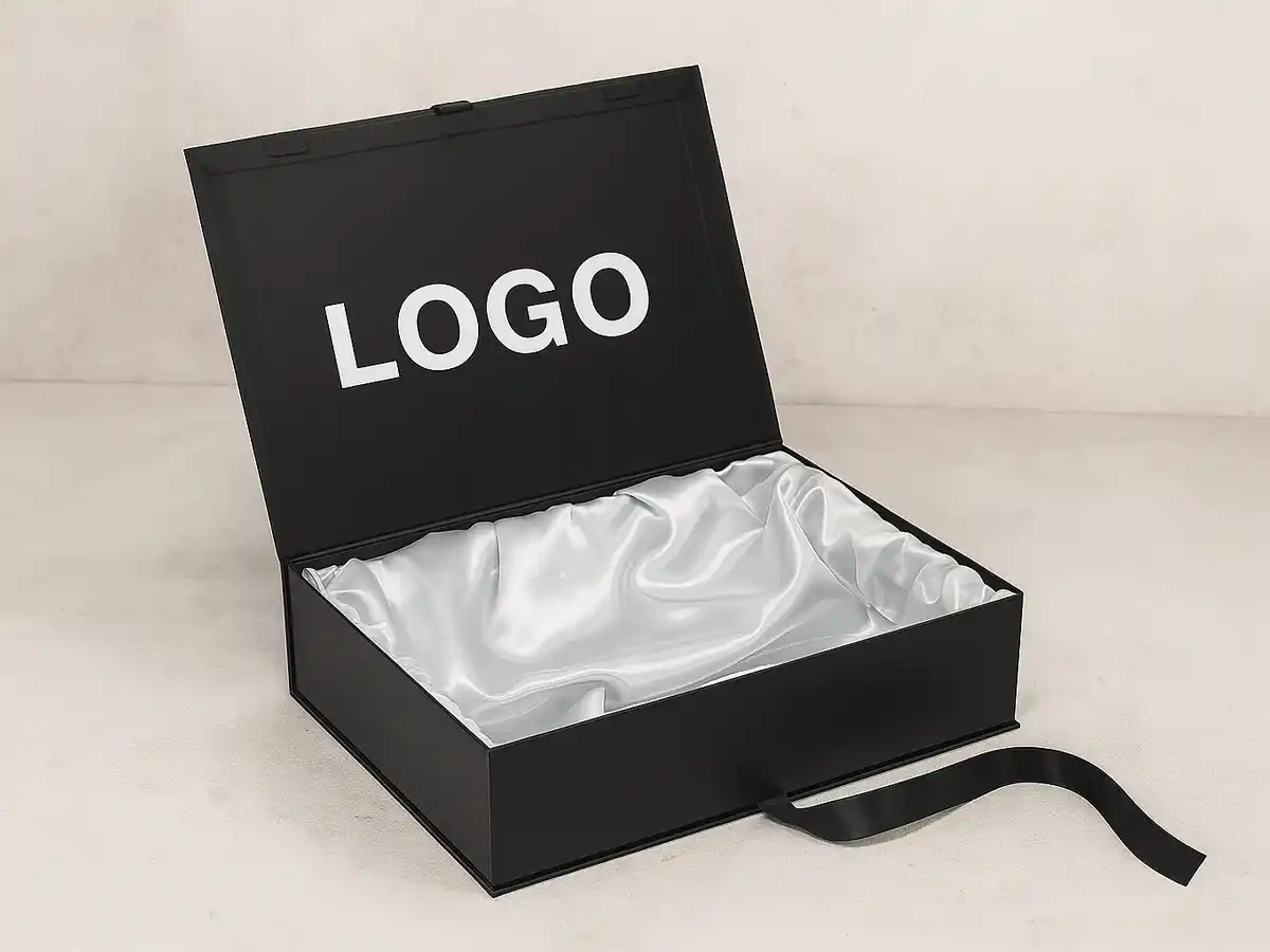 Luxury black magnetic gift box with satin lining and ribbon closure.