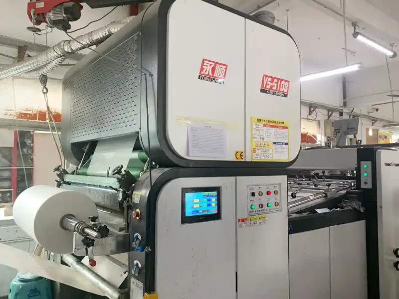 Industrial lamination machine operating in packaging production workshop