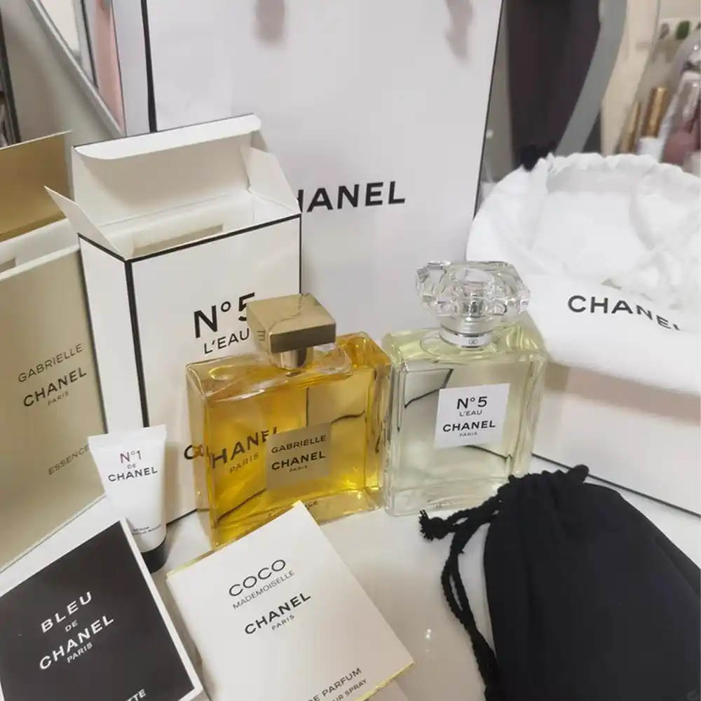 Chanel perfume bottles with luxury white paper packaging and gift bag.