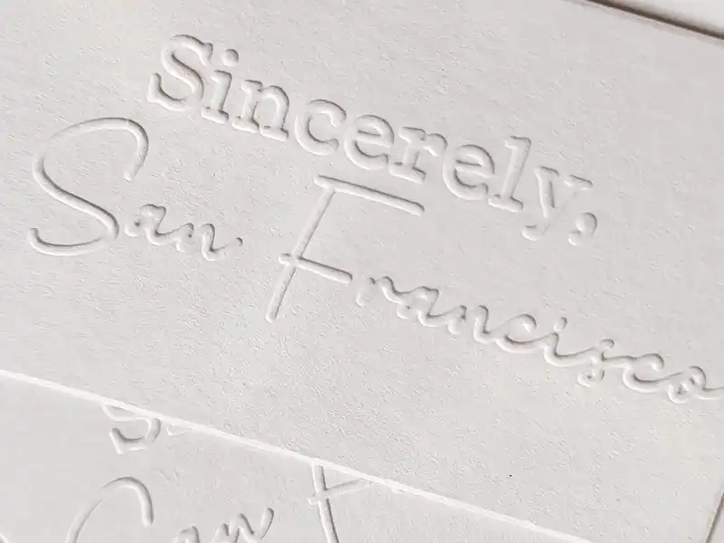 Embossed white card with elegant cursive lettering.