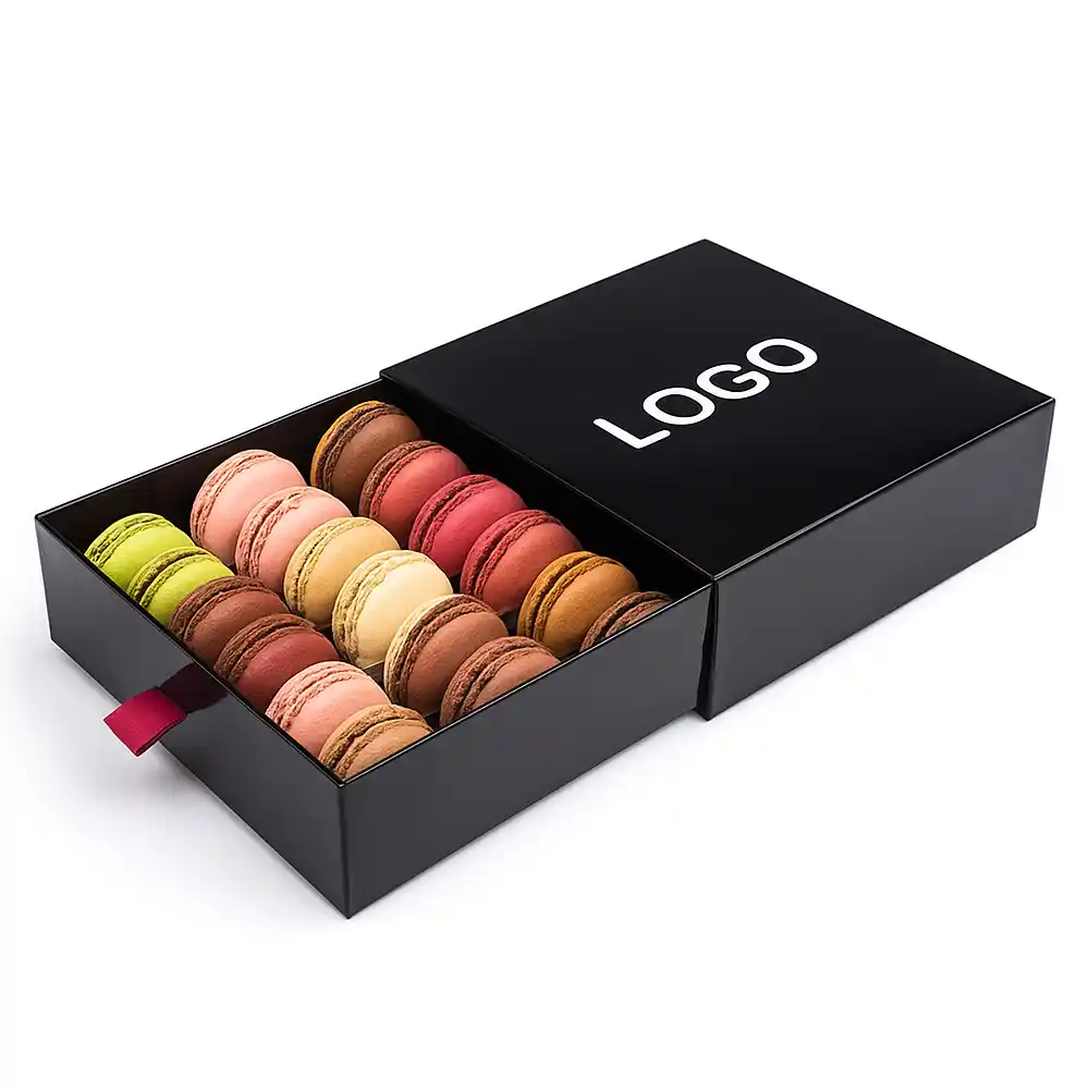 Black drawer-style macaron box with ribbon pull and assorted colorful macarons