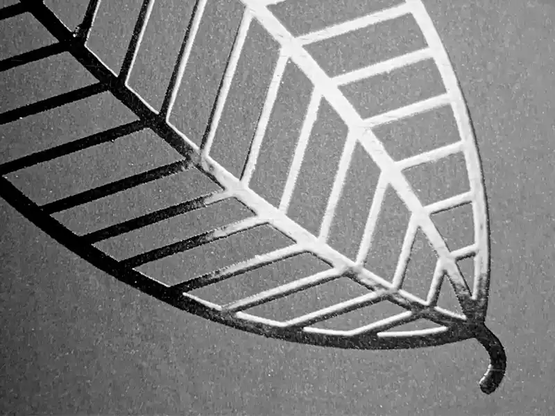 Embossed leaf design with spot UV coating on paper packaging.