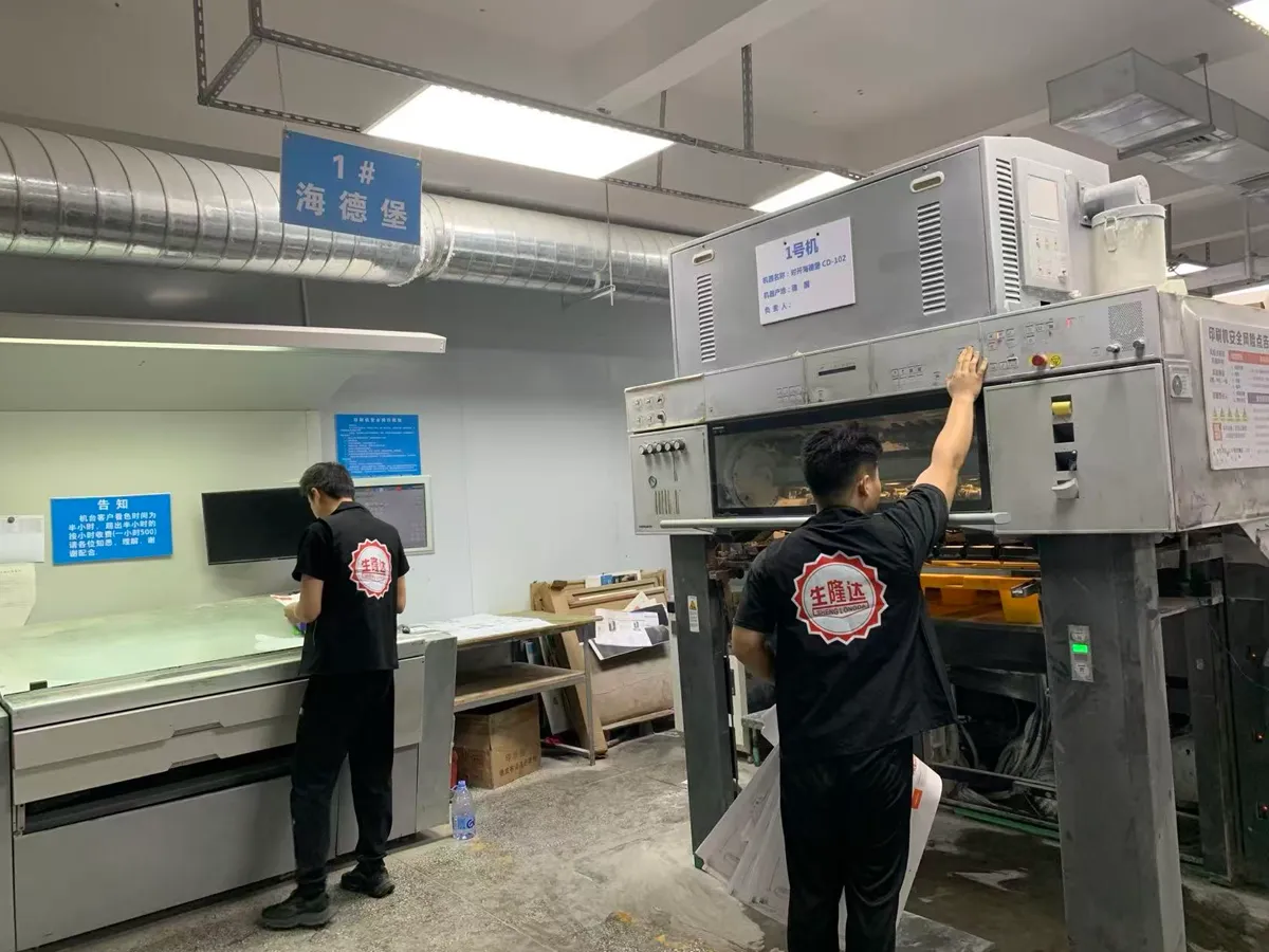 Paper packaging production team checking printing equipment in the factory